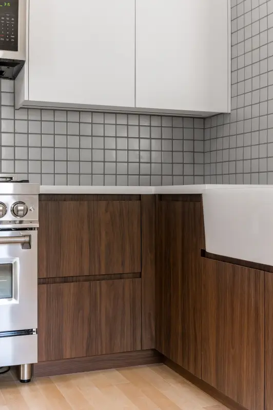 Flat-panel walnut lowers under white uppers with a square-tile backsplash