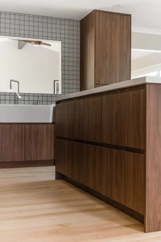 Handleless walnut island with integrated finger-pull reveals